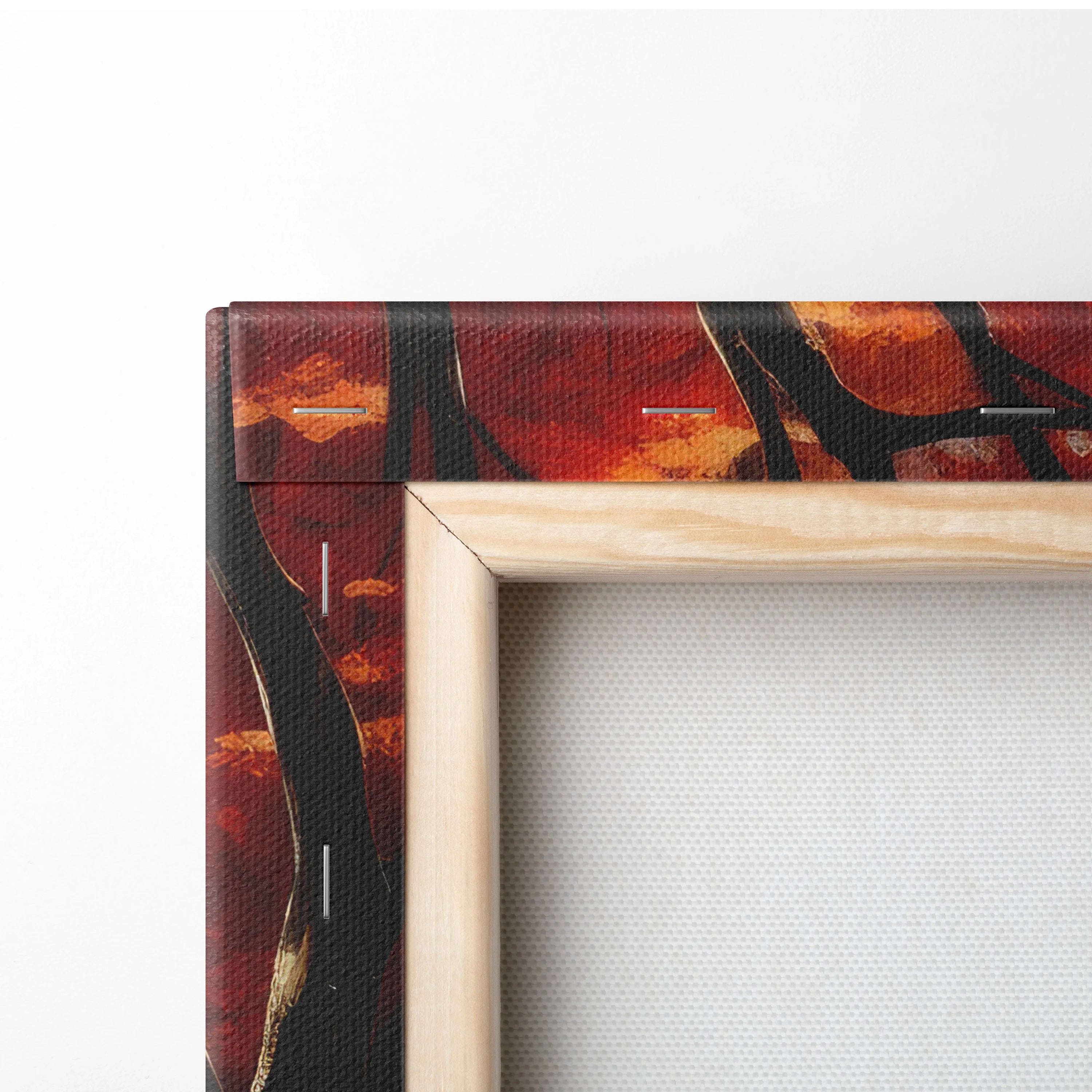 Close-up of wooden frame corner on autumn forest watercolor canvas wall art with vibrant orange and red leaves.
