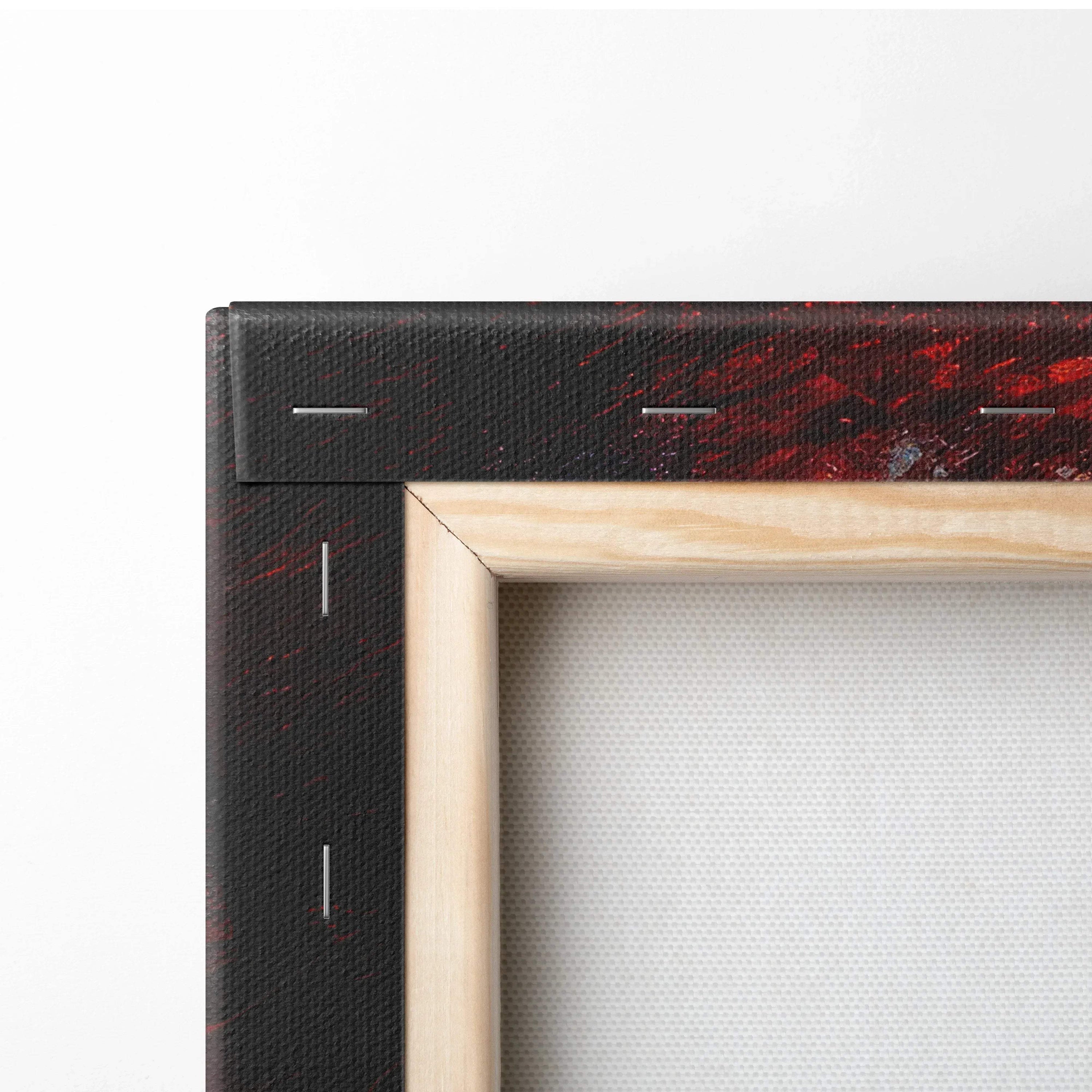 Close-up of wooden framed canvas wall art with red and black abstract design on the edge.