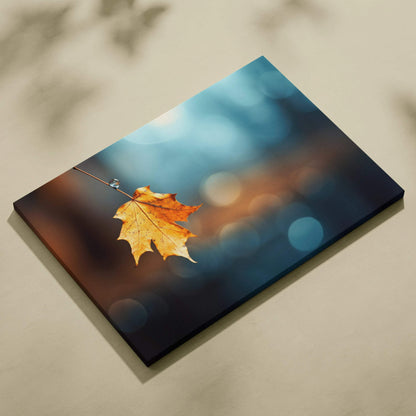 Canvas art featuring a single golden autumn leaf suspended against a blurred blue and brown woodland background wall art.