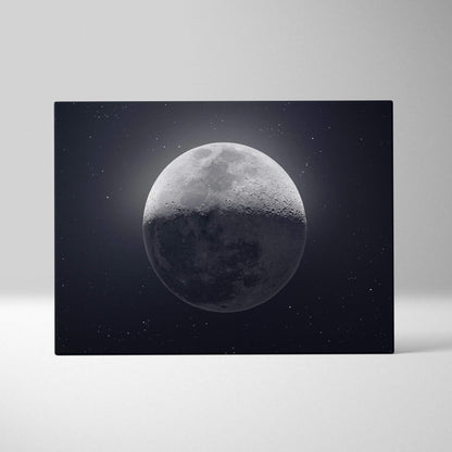 Black canvas print of half-lit grayscale moon in starry midnight blue sky