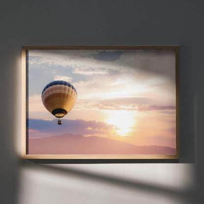 Hot air balloon at sunset over mountains wall art poster with warm colors in wooden frame.