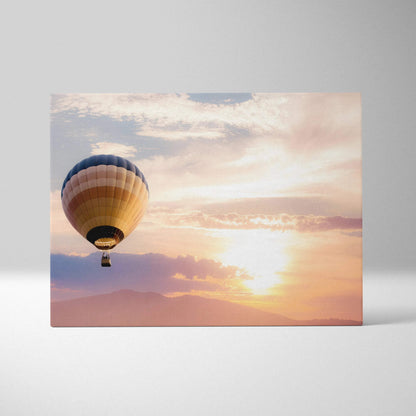 Rectangular canvas wall art featuring a hot air balloon with blue beige and tan stripes against a warm sunset sky