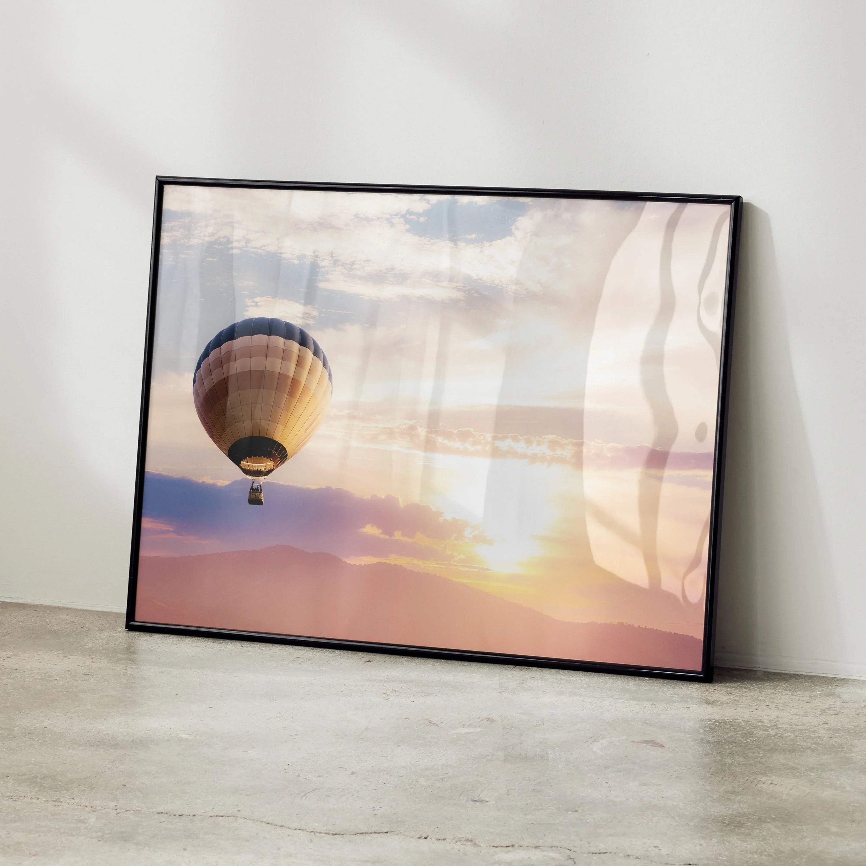 Sunset wall art poster with hot air balloon against colorful sky in black frame.