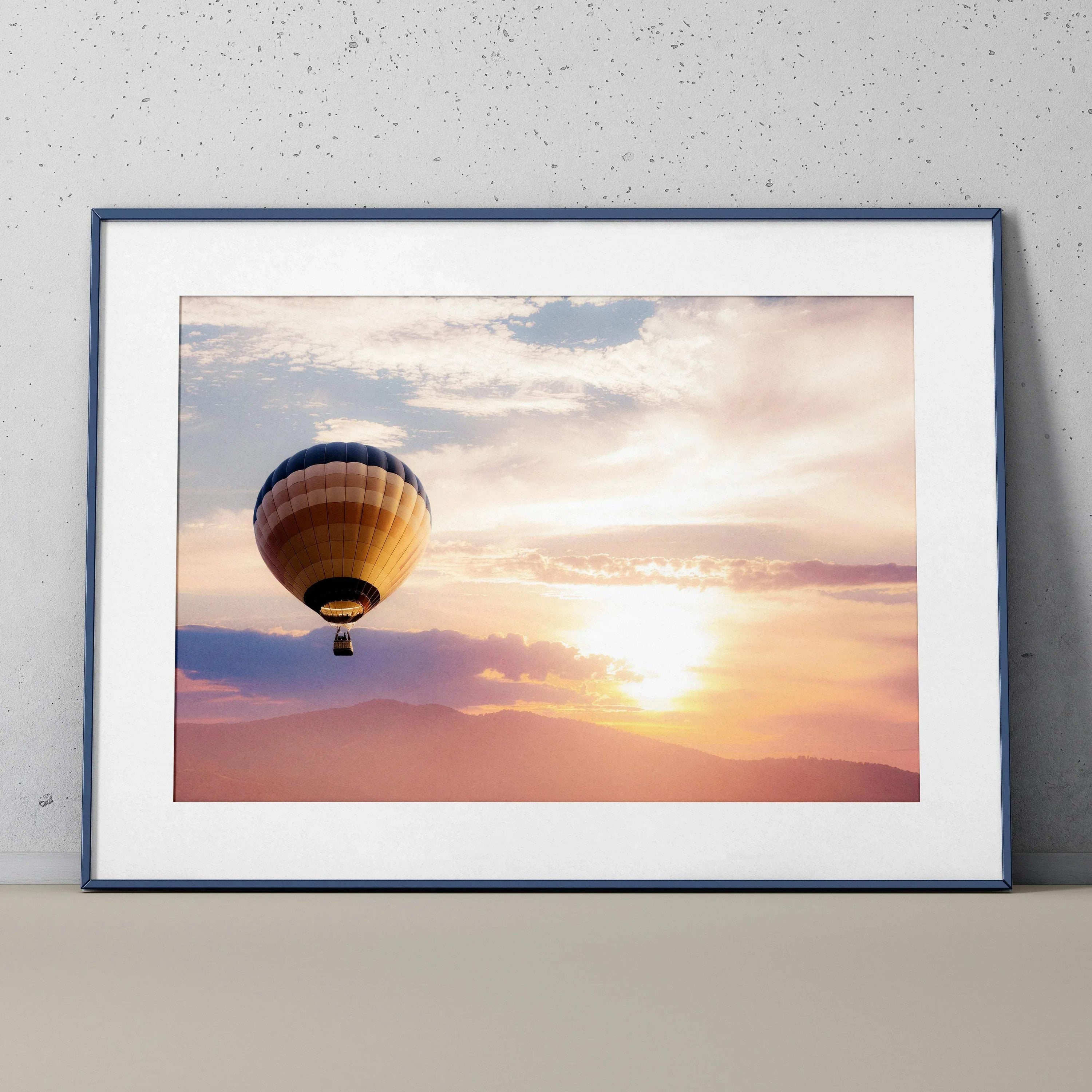 Wall art poster featuring a hot air balloon against a colorful sunset sky with soft clouds.