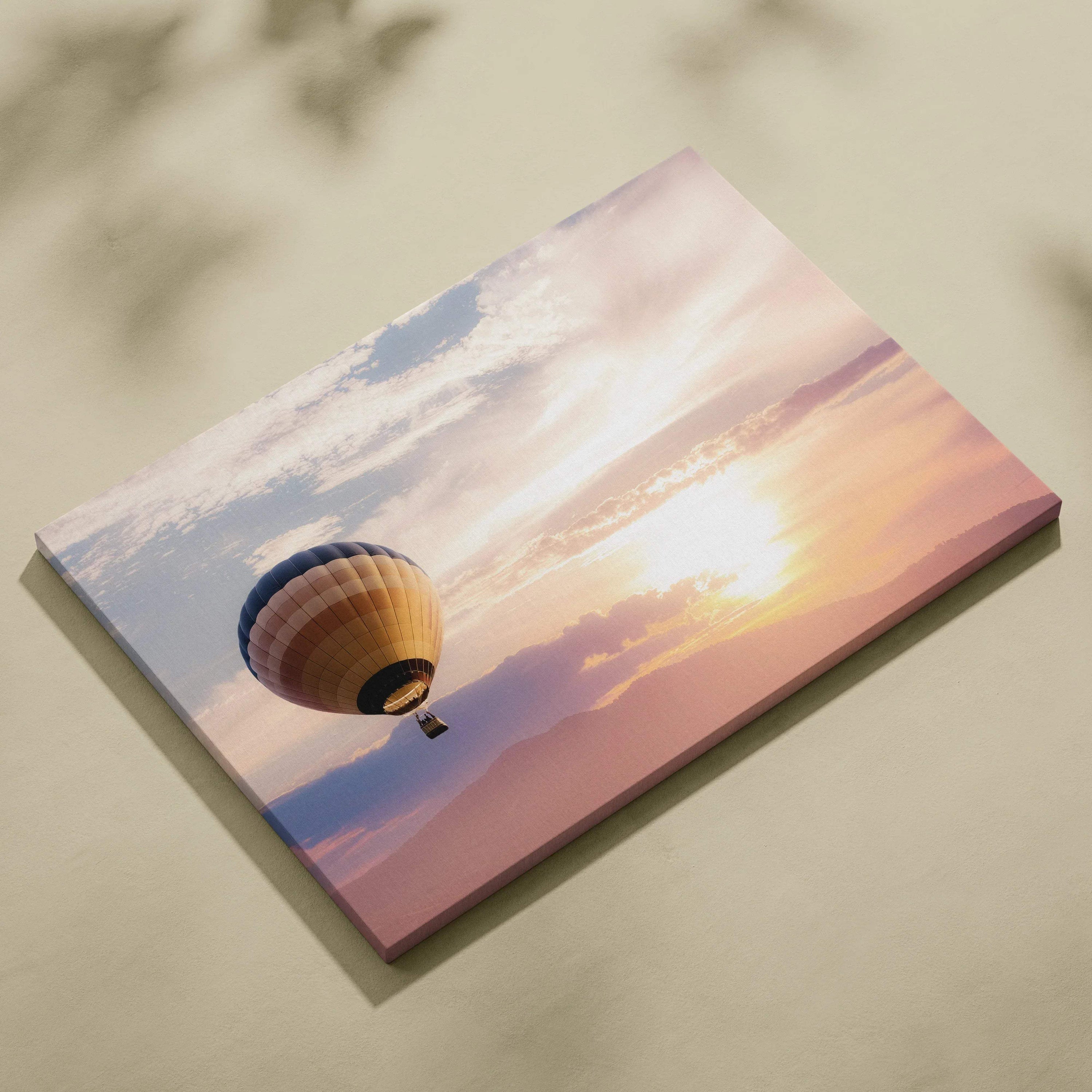 Rectangular canvas wall art featuring a hot air balloon with blue tan and gold stripes against a warm peach sunset sky