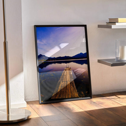 Sunset over mountain range reflected in lake with wooden pier, vertical wall art poster.