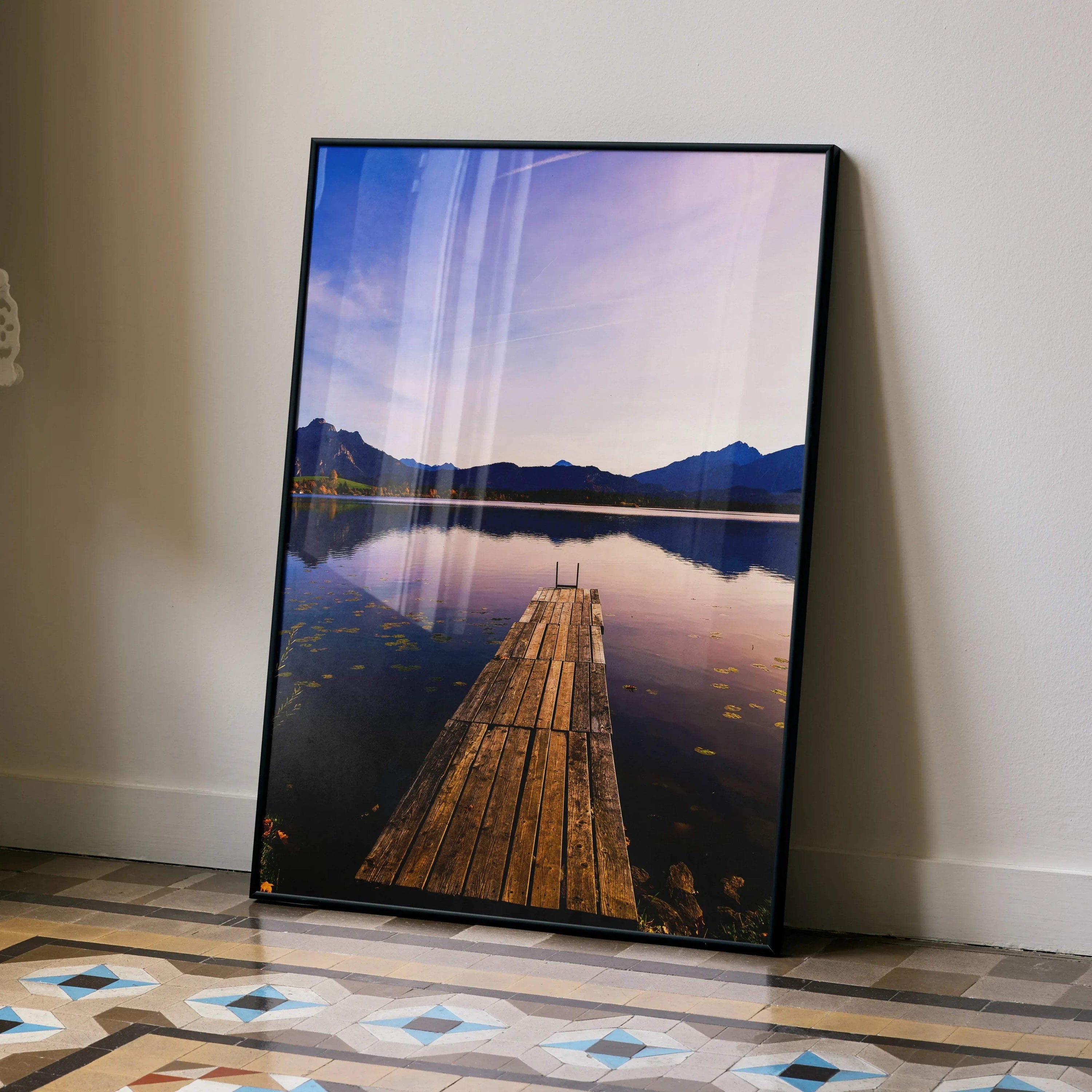 Stunning sunset poster with wooden dock leading into calm lake and mountain silhouette wall art.