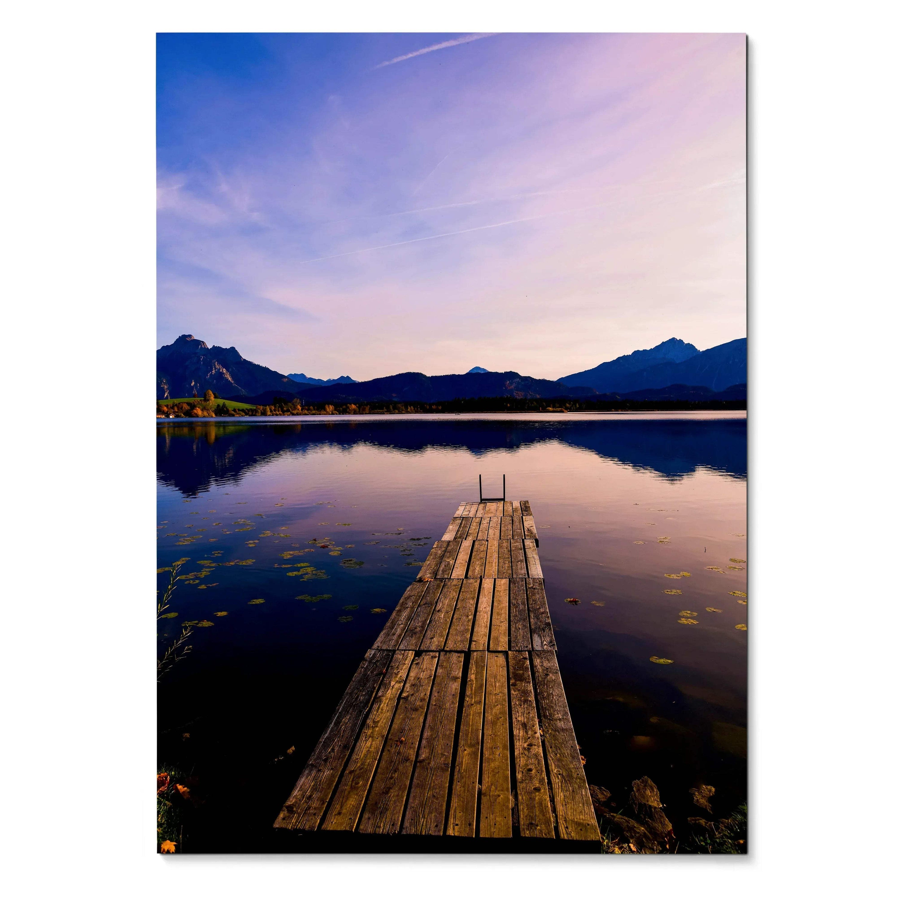 Vertical wall art poster of wooden dock extending into calm lake with mountain silhouettes at sunset.