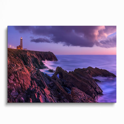 Sunset beach wall art poster with lighthouse on rocky coastline and ocean waves.