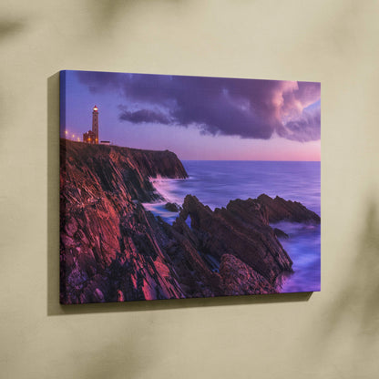 Canvas wall art featuring a rocky coastline with a lighthouse at sunset and a purple-pink sky.