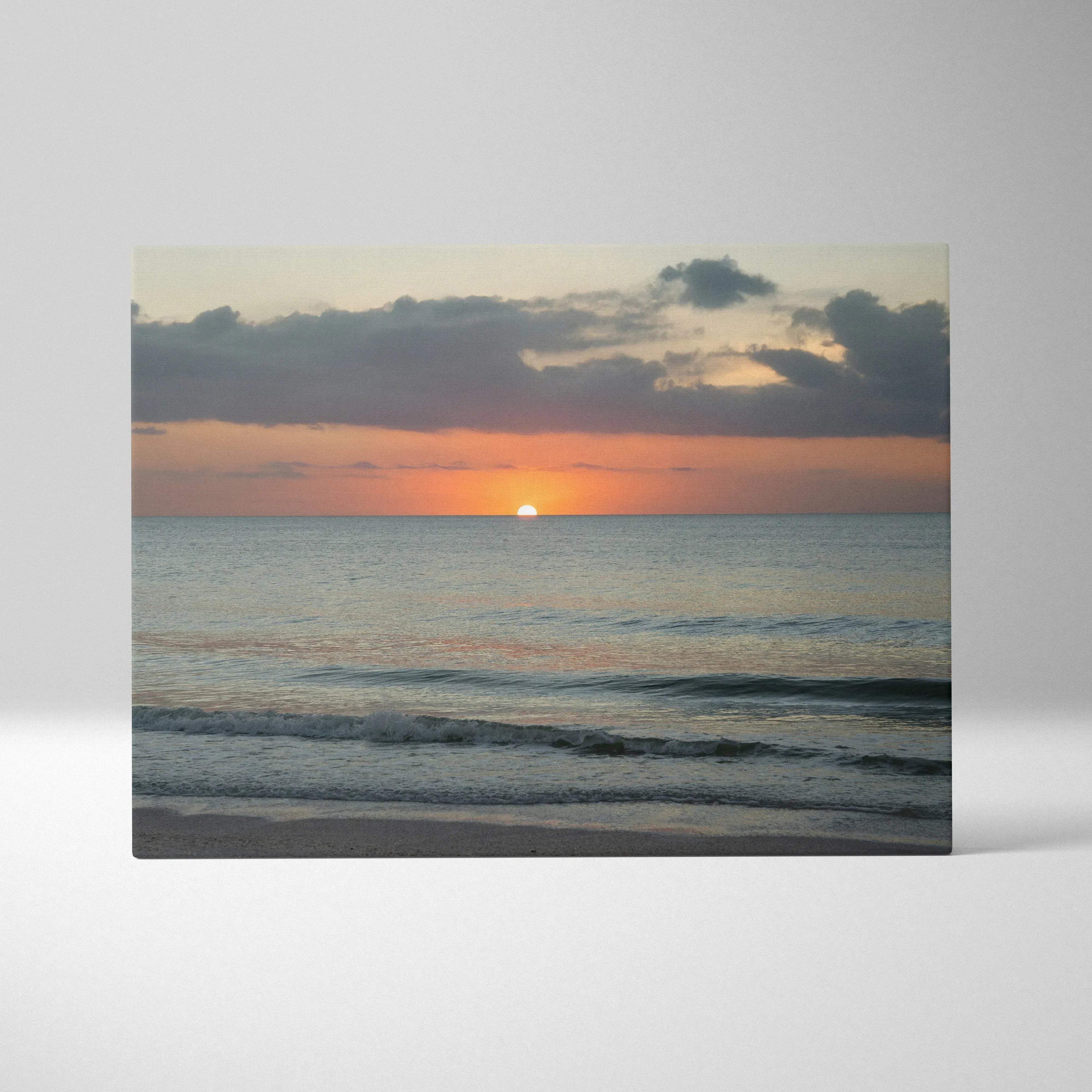 Sunset over calm ocean waves on canvas wall art with soft orange and blue tones.