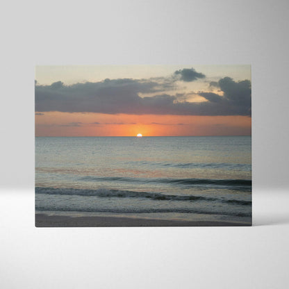 Sunset over calm ocean waves on canvas wall art with soft orange and blue tones.