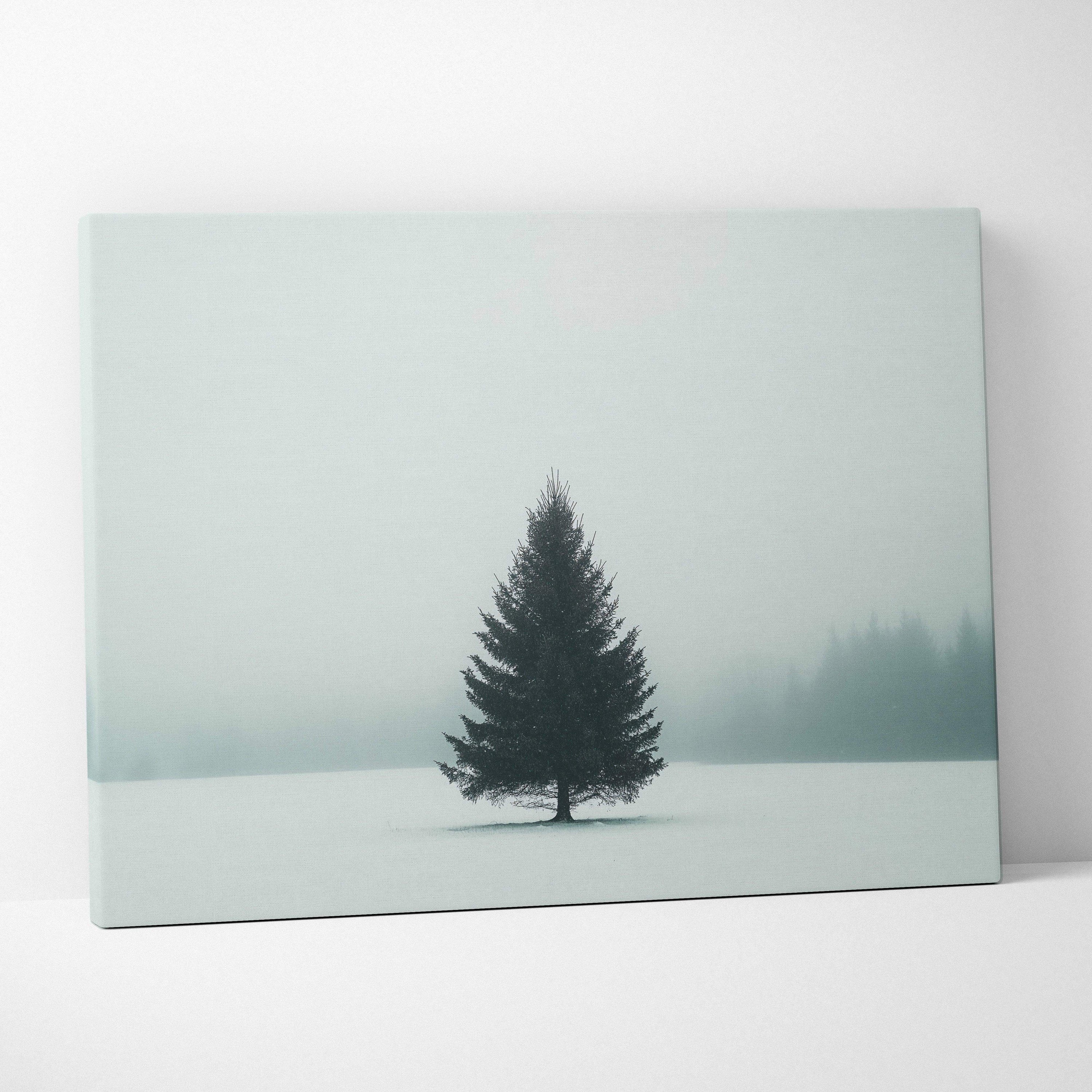 Canvas wall art featuring a solitary evergreen tree in a misty snowy landscape with soft muted tones.