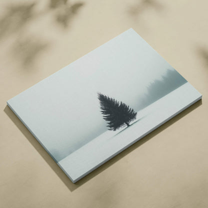 Canvas wall art featuring a solitary evergreen tree in a snowy, foggy landscape with muted tones.