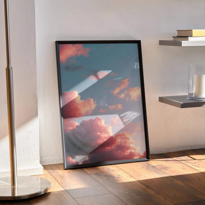 Vertical sunset nature poster wall art with vibrant clouds in black frame on wooden floor.
