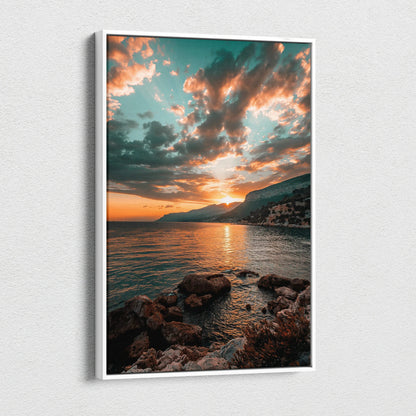 Vertical canvas wall art featuring a colorful sunset over mountains and rocky shoreline.
