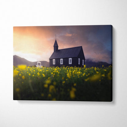 Black wooden church in yellow wildflowers at sunset canvas print