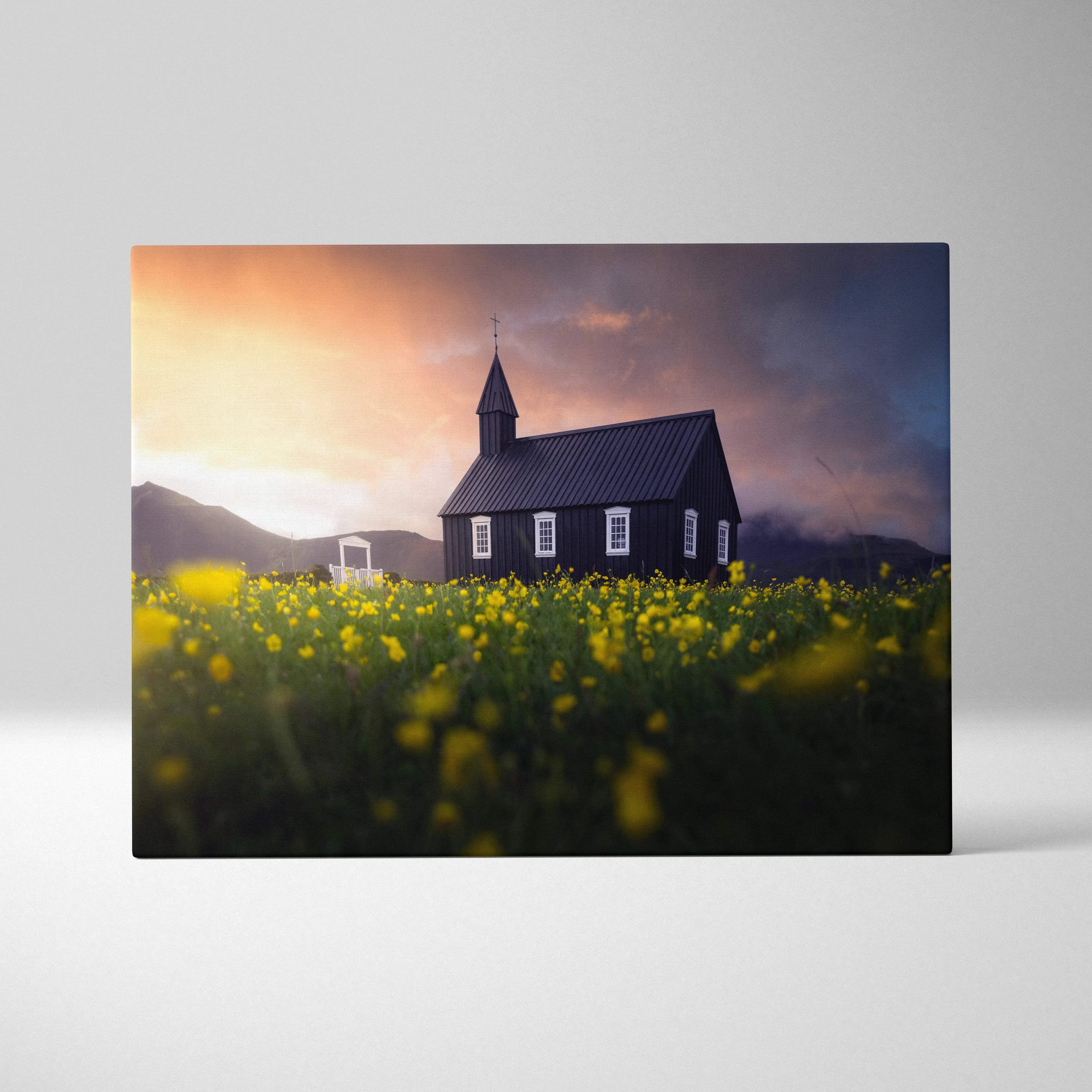 Black wooden church in yellow wildflowers at sunset canvas wall art