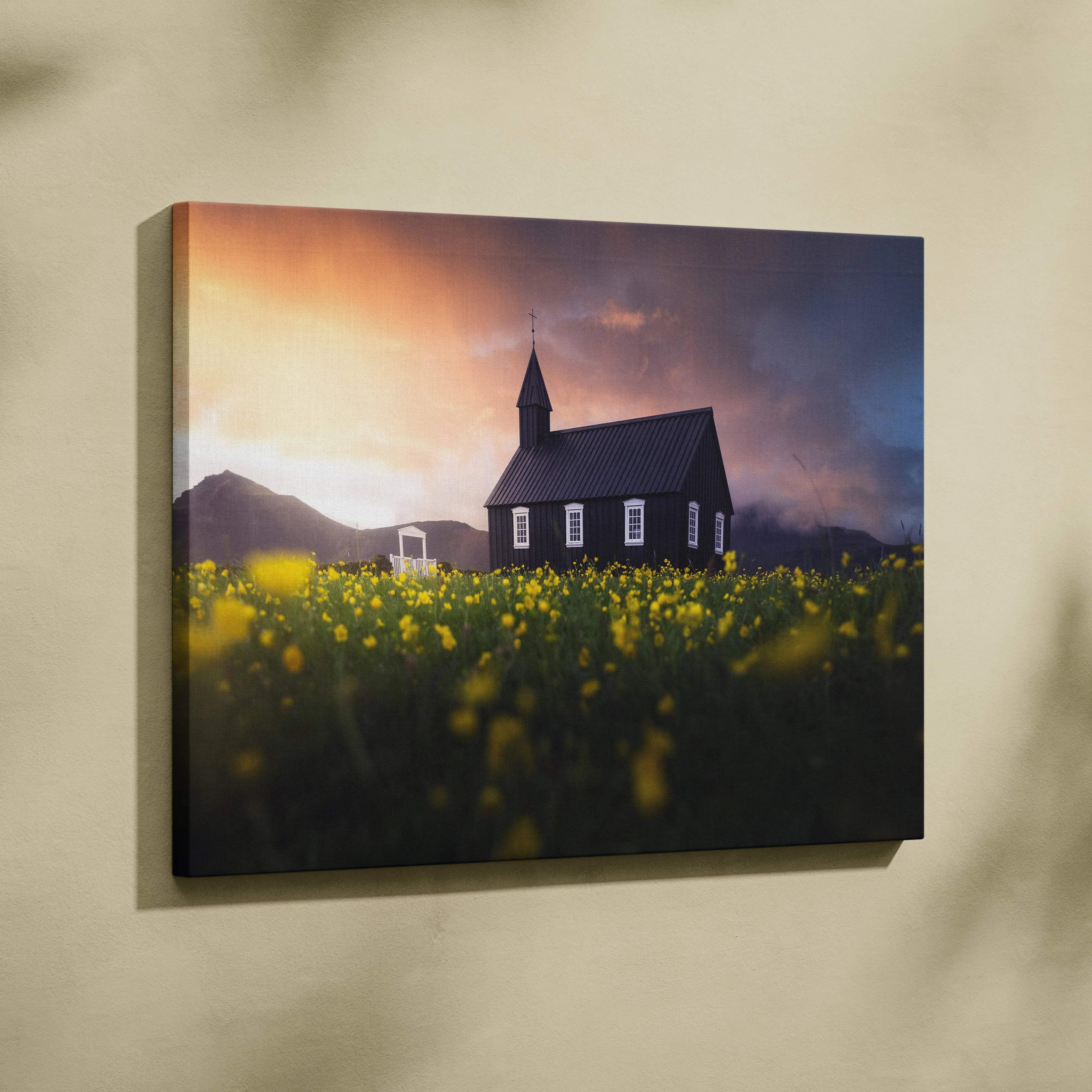 Black wooden church in yellow wildflowers at sunset canvas print
