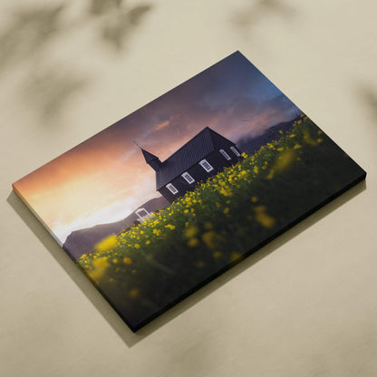 Black canvas print of church in yellow wildflowers at moody sunset