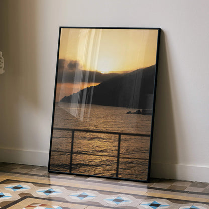 Vertical beach sunset poster with golden sky, dark silhouette cliffs, and calm water wall art.
