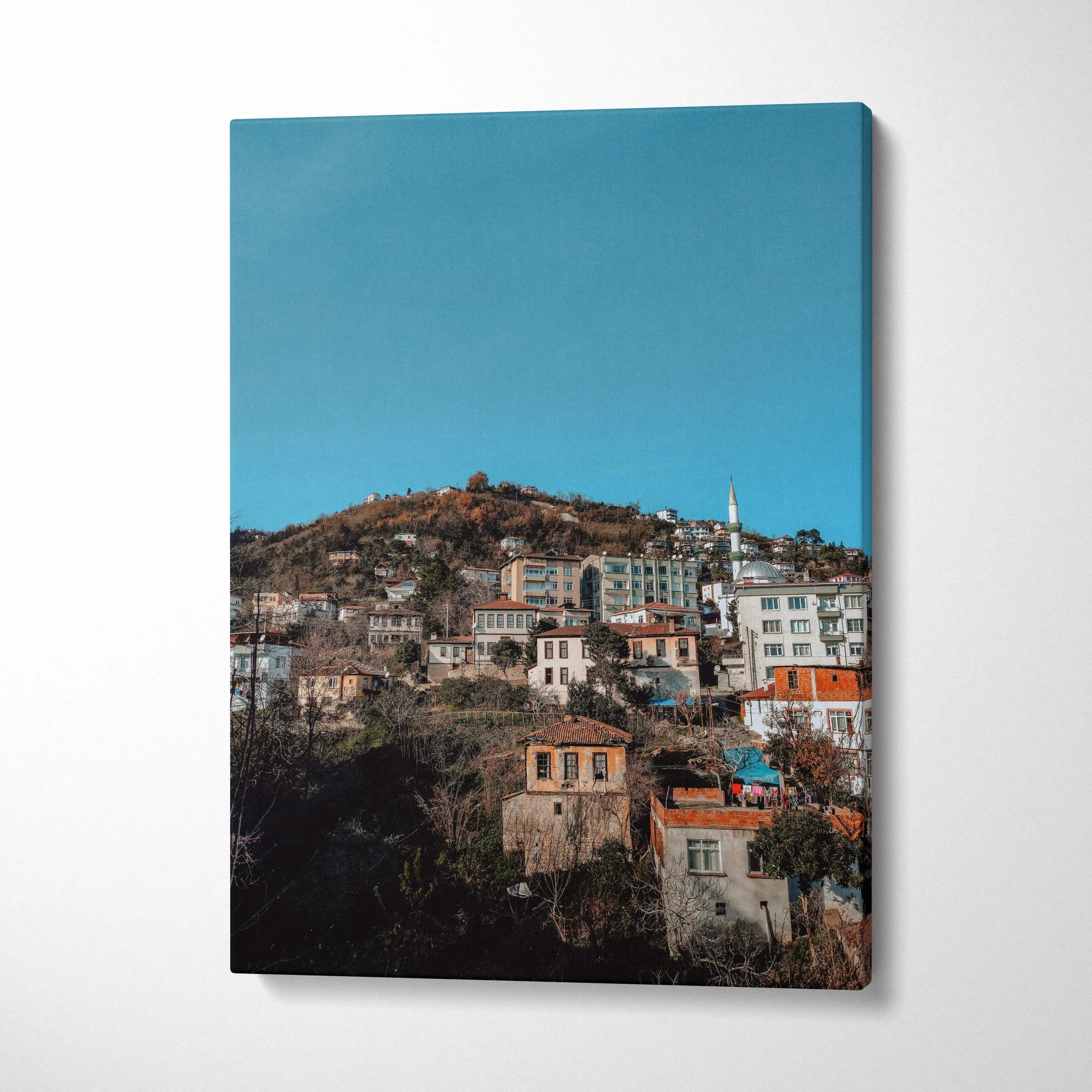 Vertical canvas wall art featuring vibrant urban cityscape with buildings under clear blue sky.