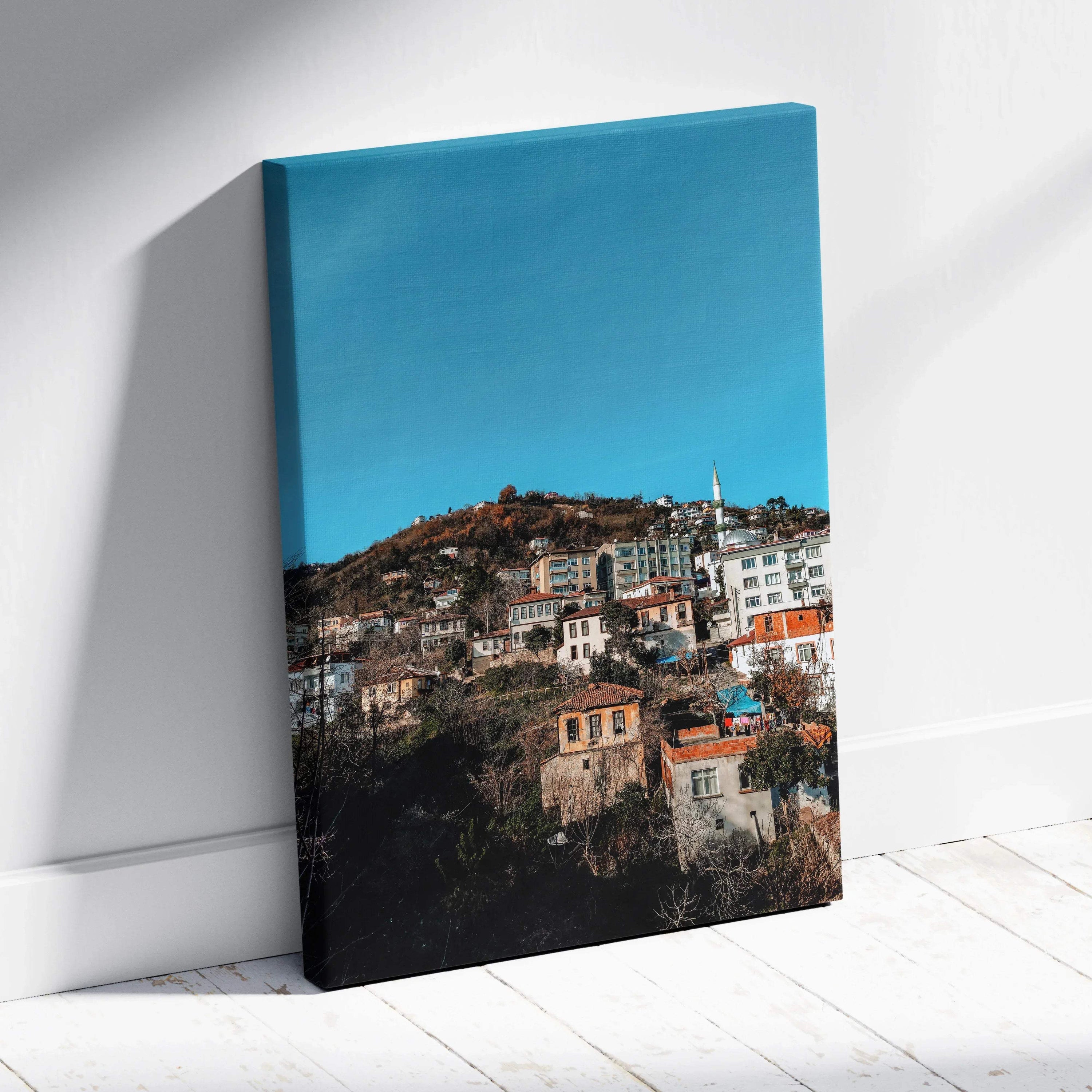 Vertical canvas wall art featuring vibrant urban cityscape with colorful buildings under clear blue sky.