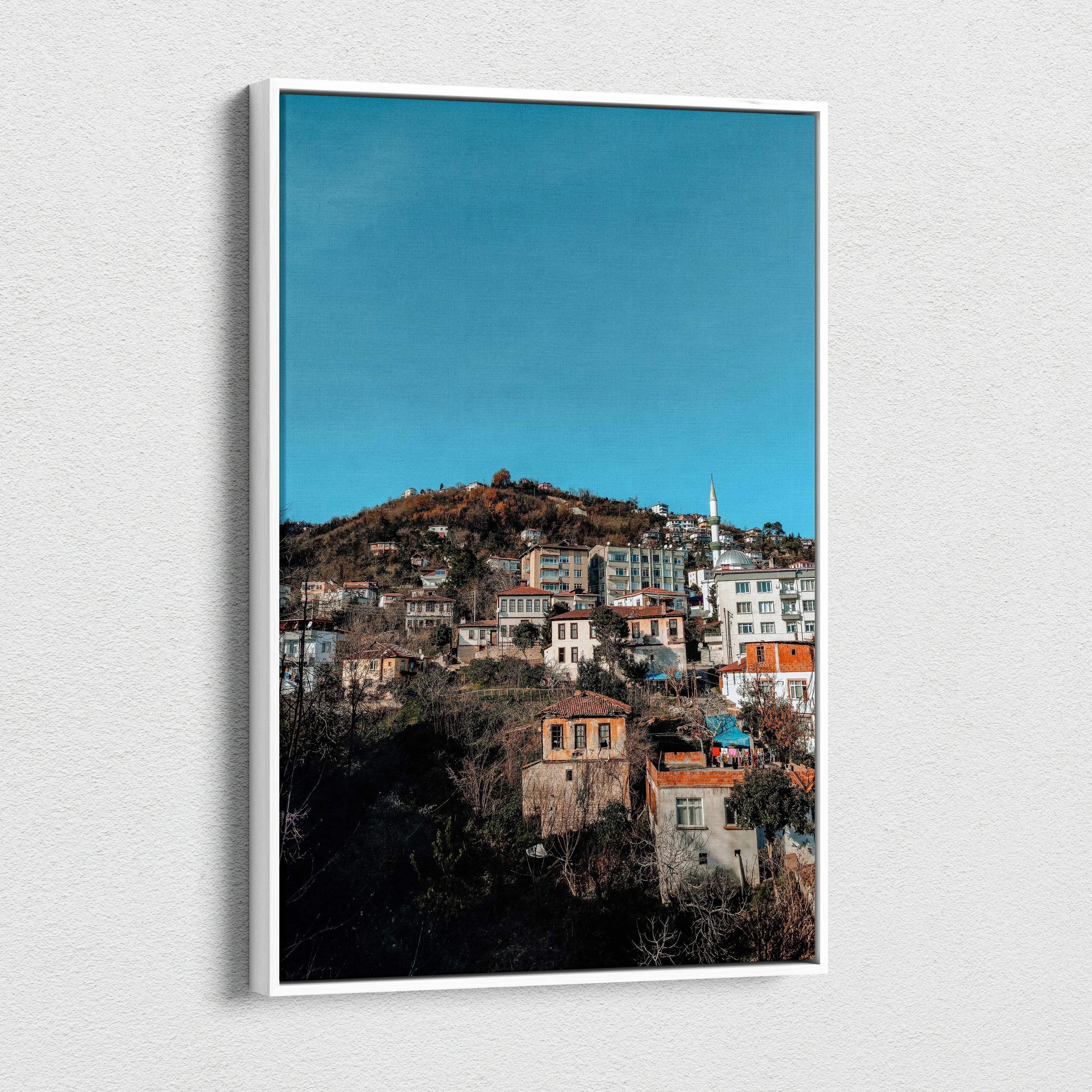 Vertical canvas wall art featuring a vibrant urban cityscape under a clear blue sky.