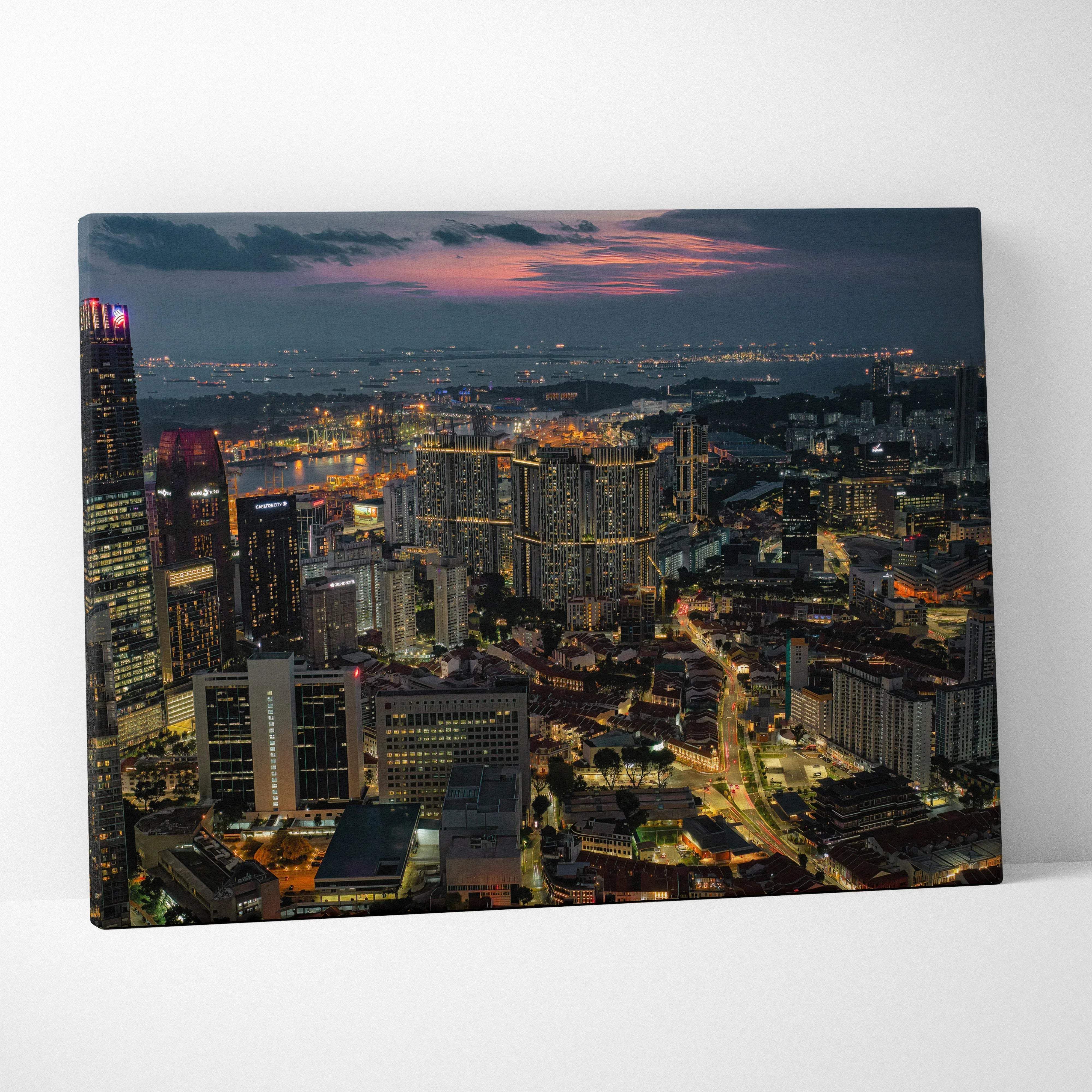 Urban night cityscape canvas wall art featuring illuminated skyscrapers at dusk with warm amber and deep blue hues