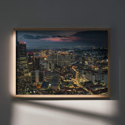 Vibrant city nightscape wall art poster with illuminated buildings and streets in a wooden frame.
