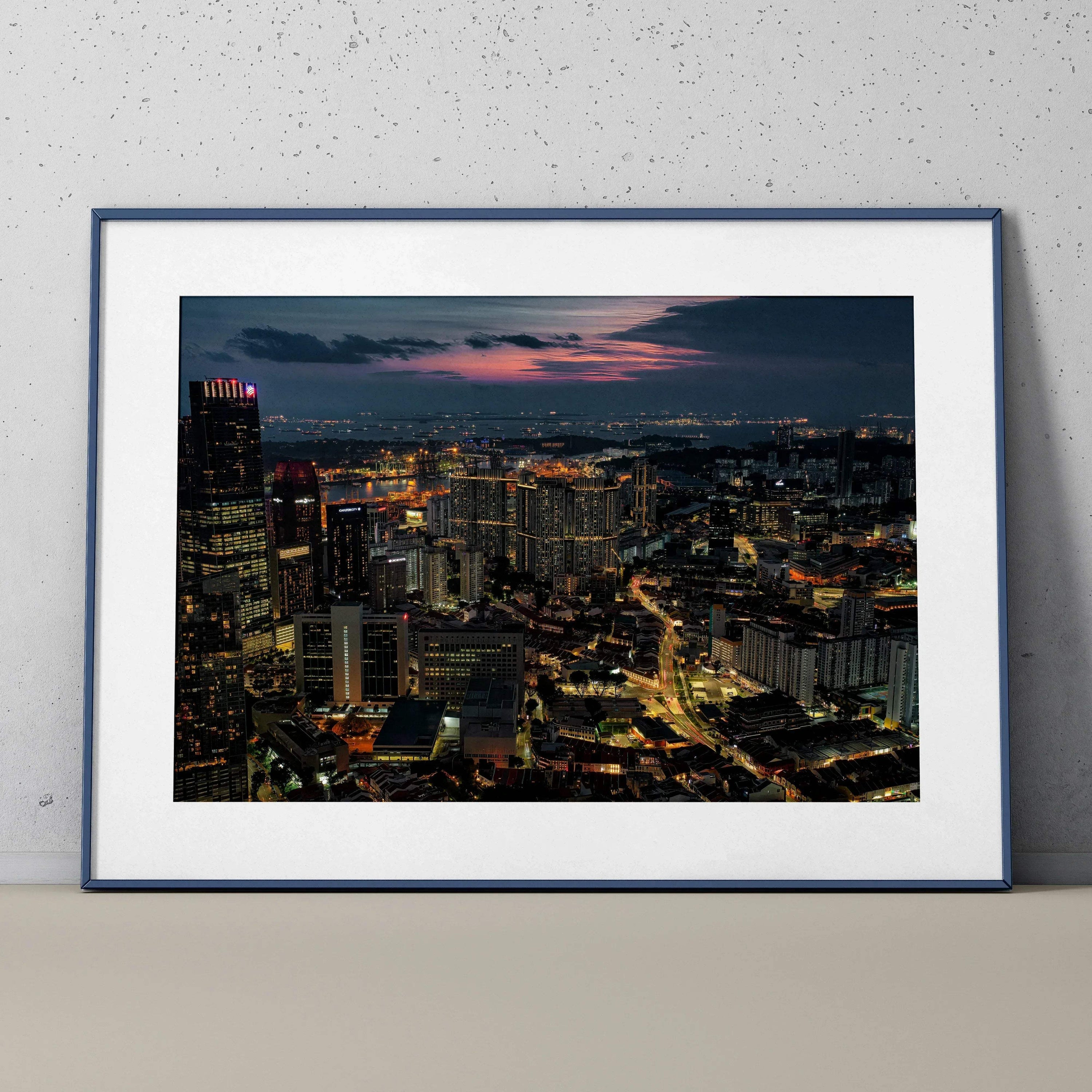 Vibrant city nightscape wall art poster with illuminated skyscrapers and streets in dark blue frame.