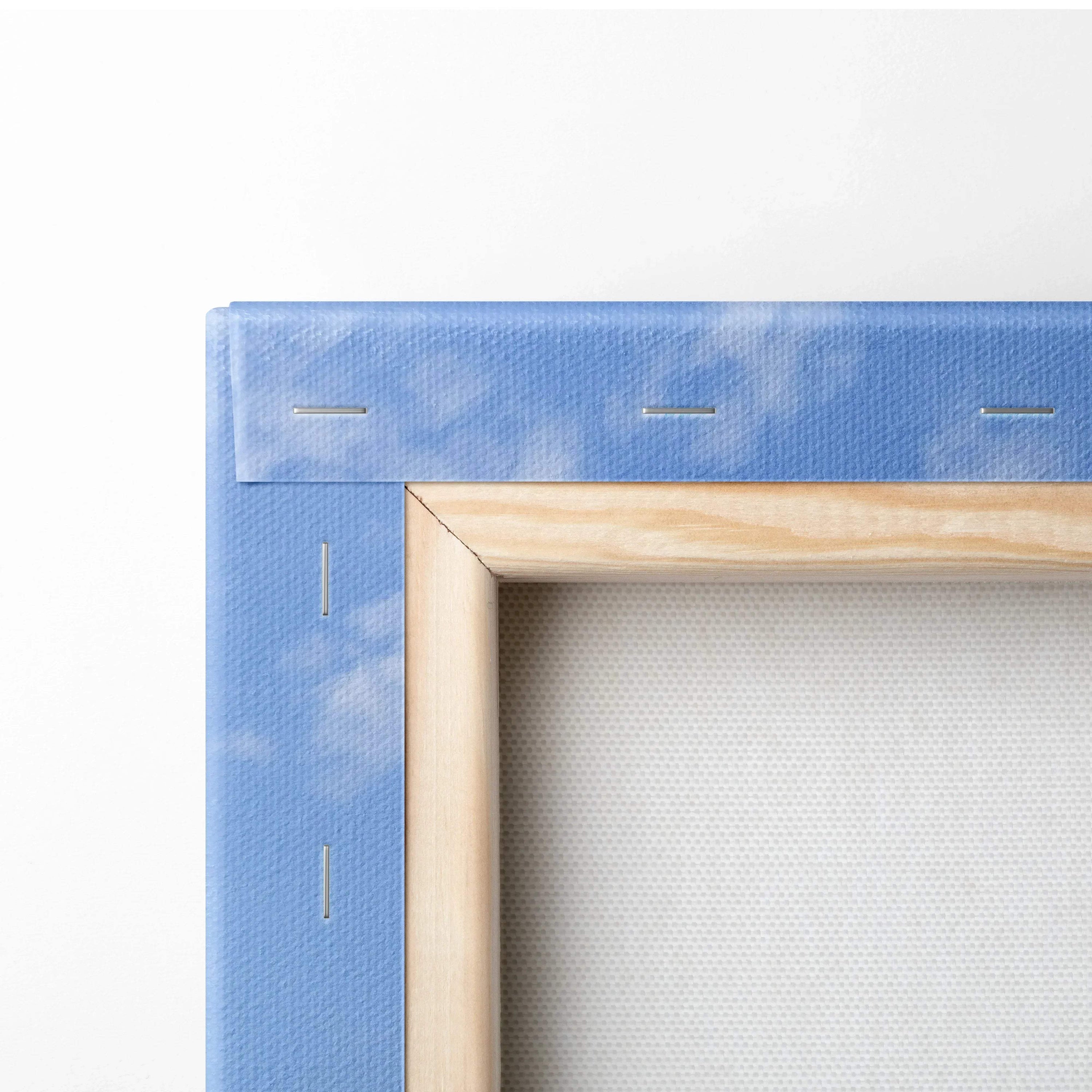 Close-up of wooden frame and blue canvas backing with sky print on wall art canvas.