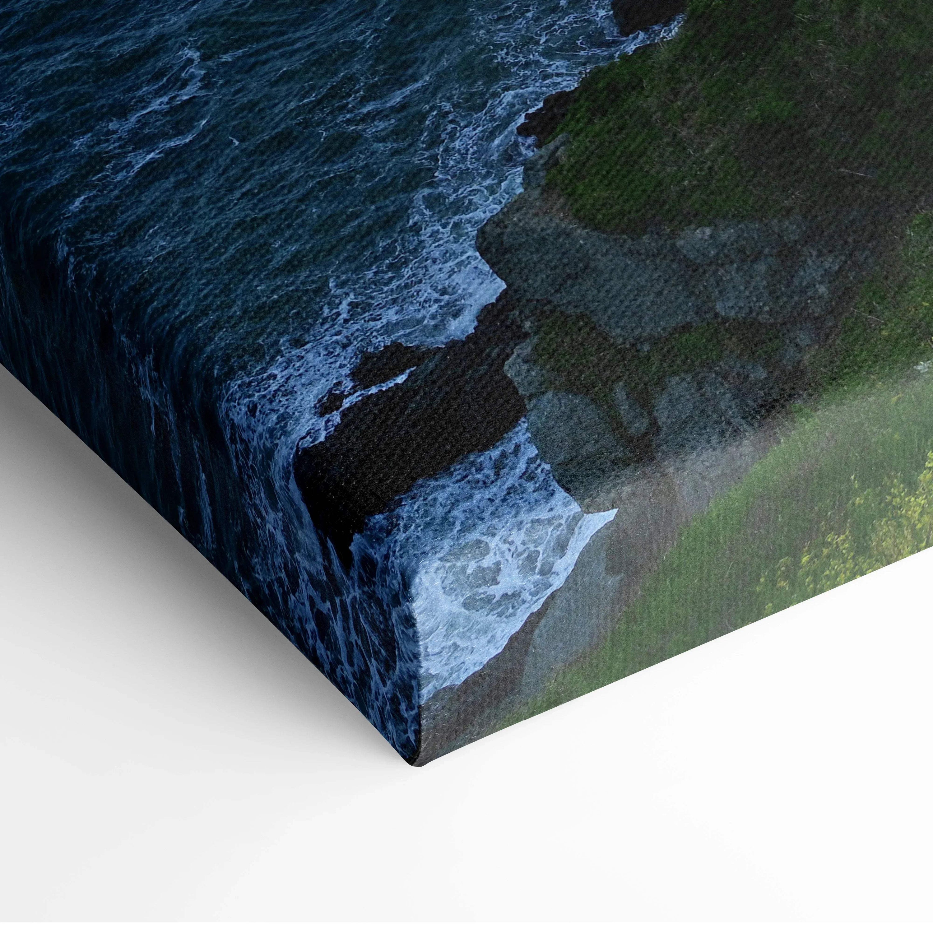 Canvas wall art depicting rocky coastline with dark waves and green cliffs at dusk.