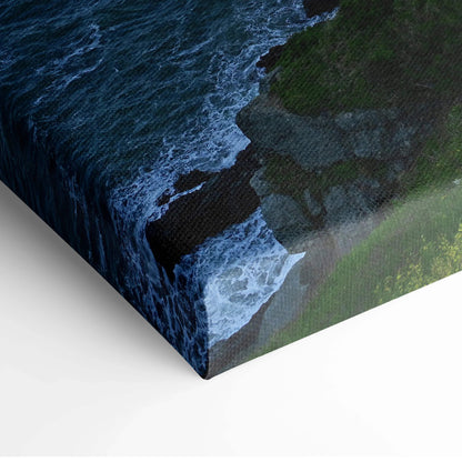 Canvas wall art depicting rocky coastline with dark waves and green cliffs at dusk.