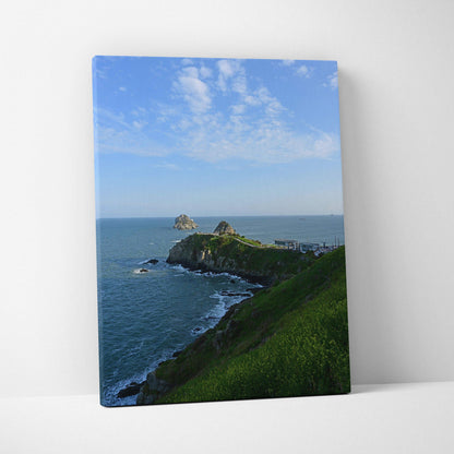 Vertical canvas wall art featuring majestic mountains meeting a tranquil beach under a blue sky.