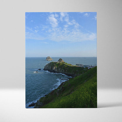 Vertical canvas wall art featuring majestic mountains and tranquil beach under a blue sky with scattered clouds.