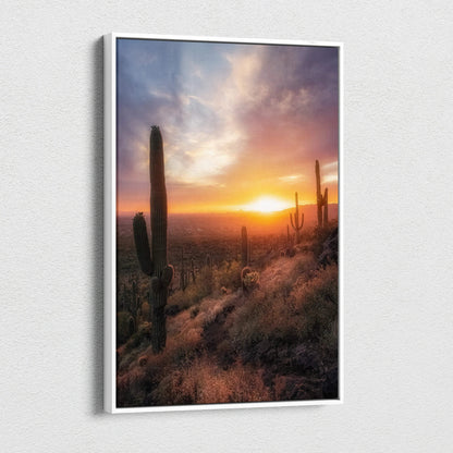 Vertical canvas wall art featuring a vibrant desert sunset with tall cacti and glowing sky.