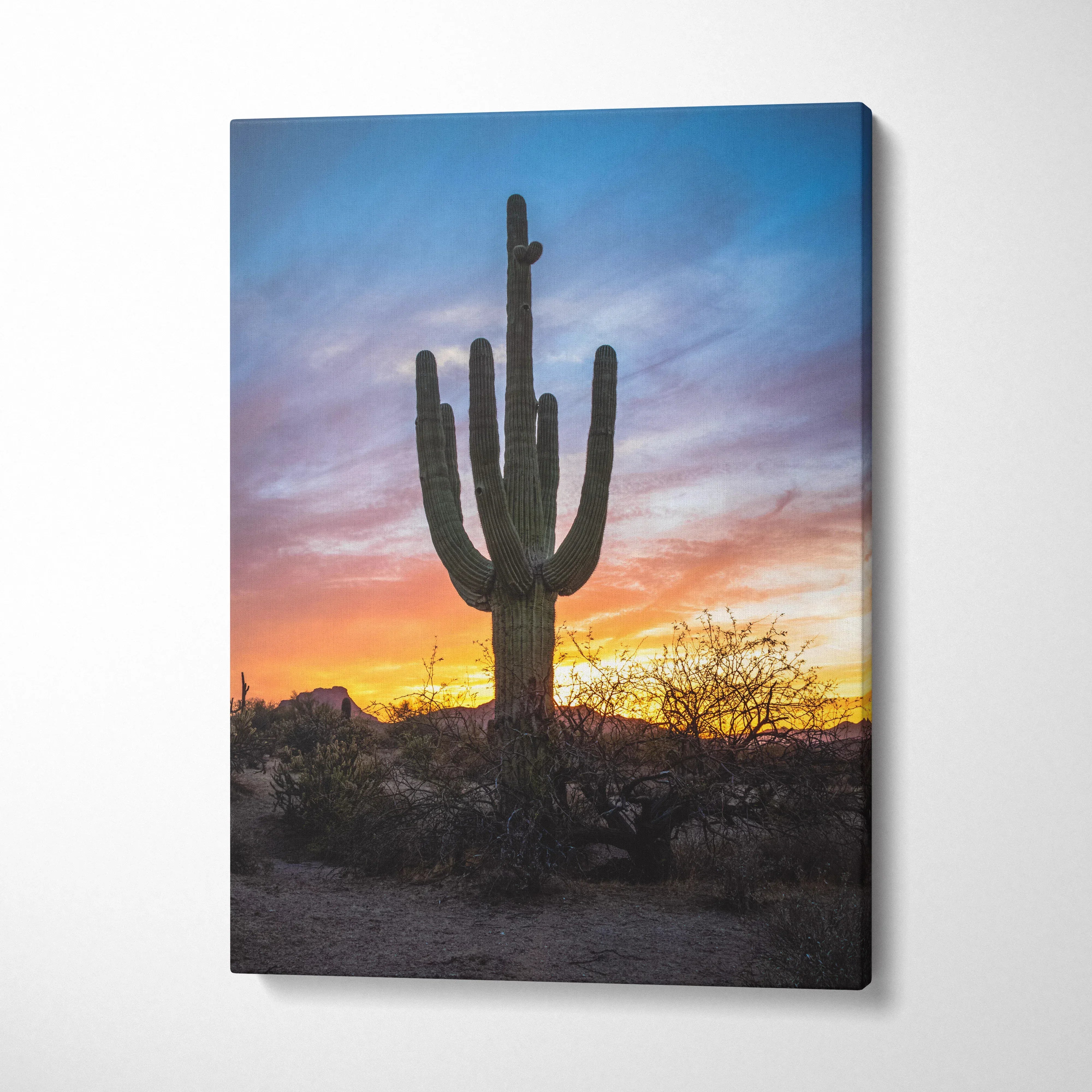 Vertical canvas wall art of a tall saguaro cactus silhouetted against a vibrant desert sunset sky.