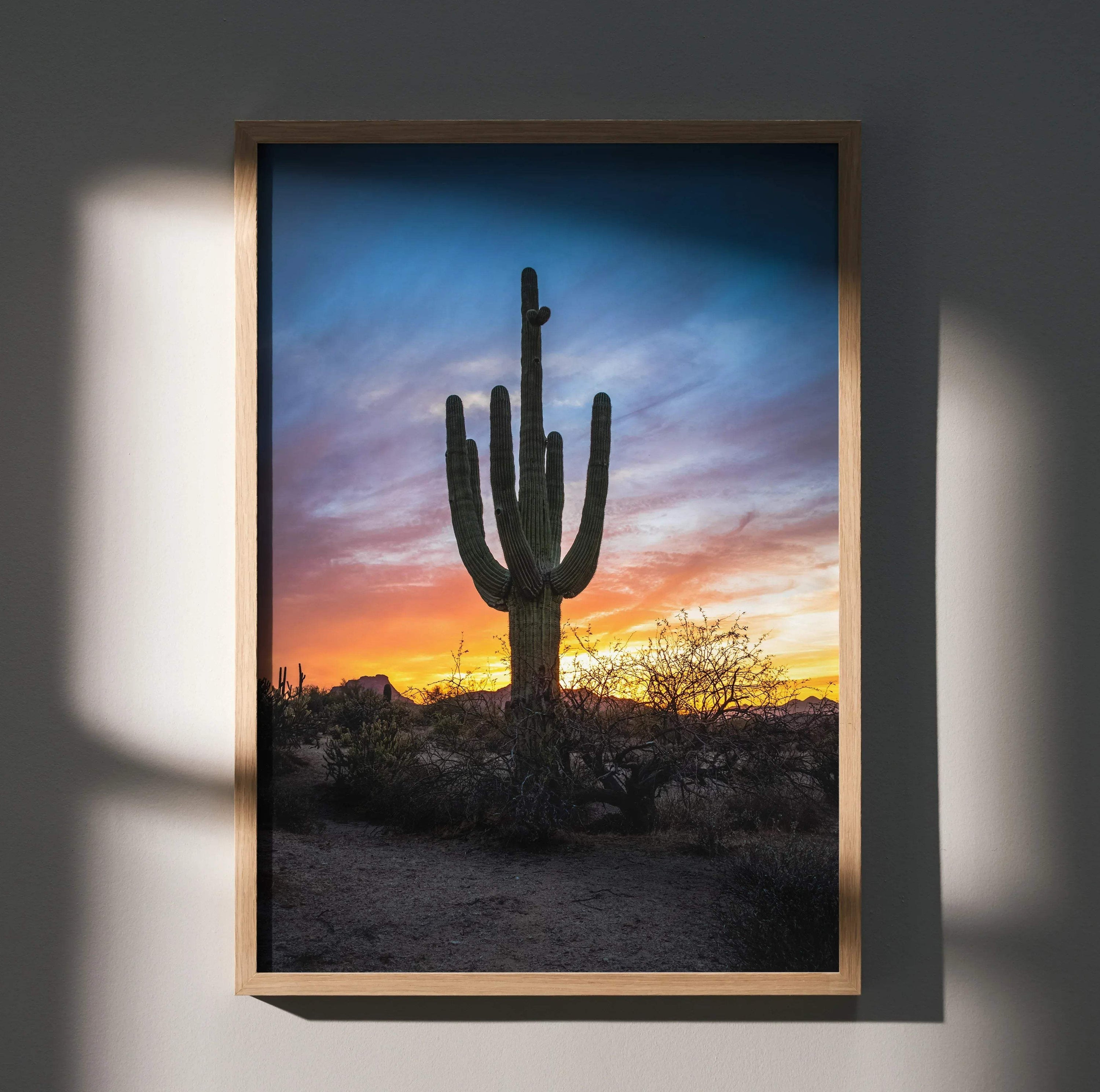 Vertical wall art poster featuring a silhouetted cactus against a vibrant desert sunset sky.