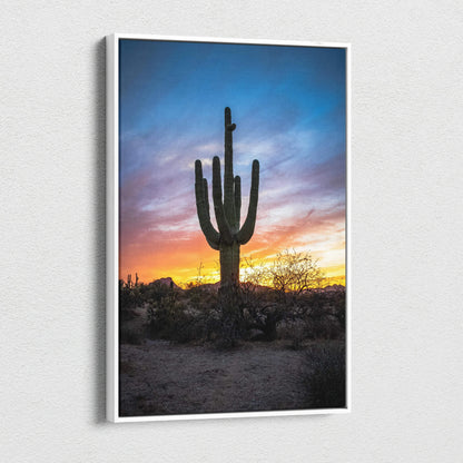 Vertical canvas wall art featuring a tall cactus silhouette against a colorful desert sunset sky.