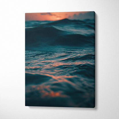 Canvas wall art featuring a dark ocean wave at sunset with warm orange and blue tones.