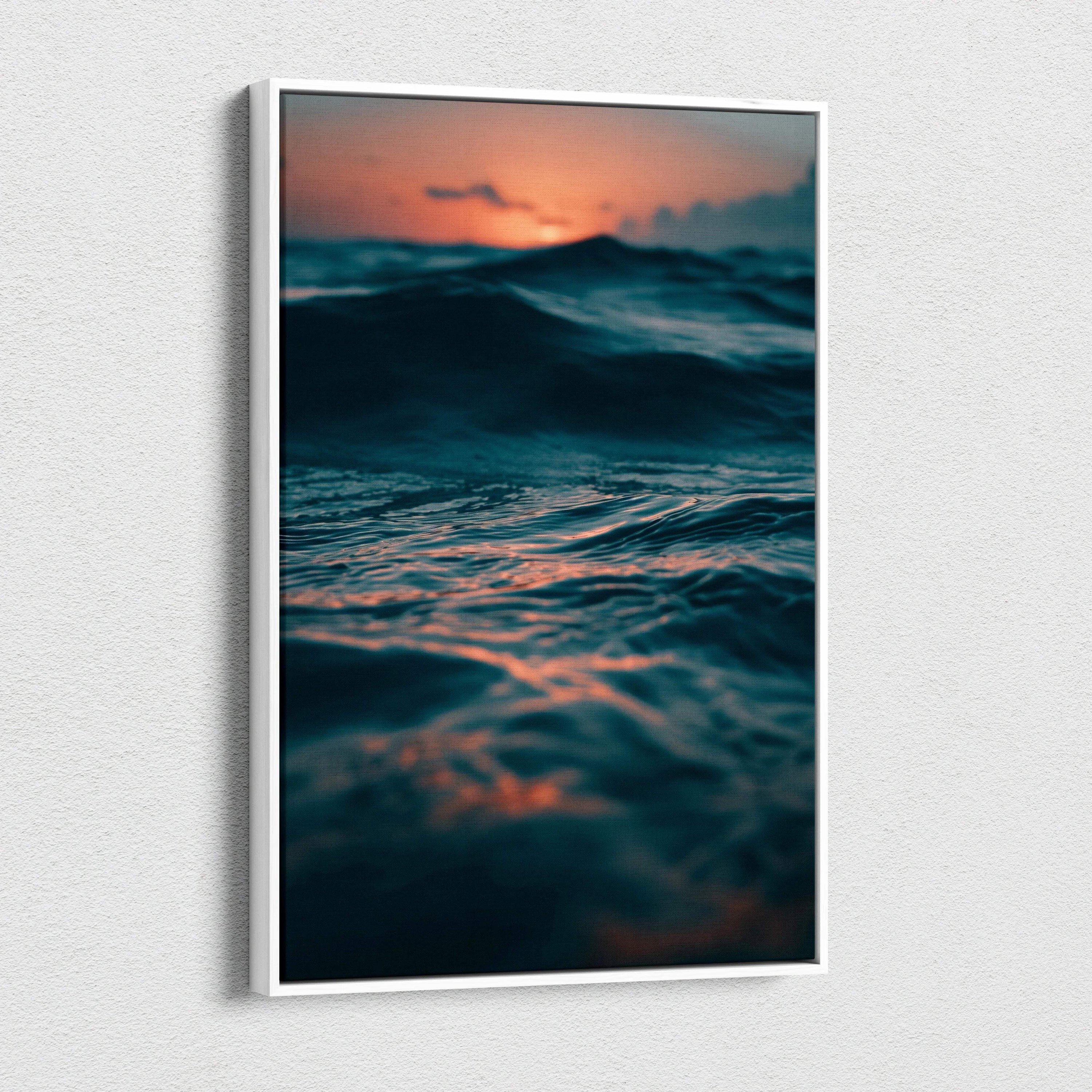 Ocean sunset canvas wall art with dark waves and glowing orange sky in vertical frame.