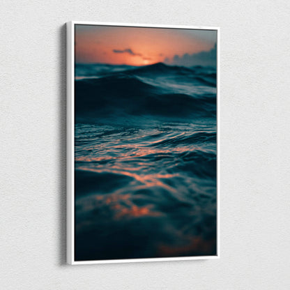 Ocean sunset canvas wall art with dark waves and glowing orange sky in vertical frame.