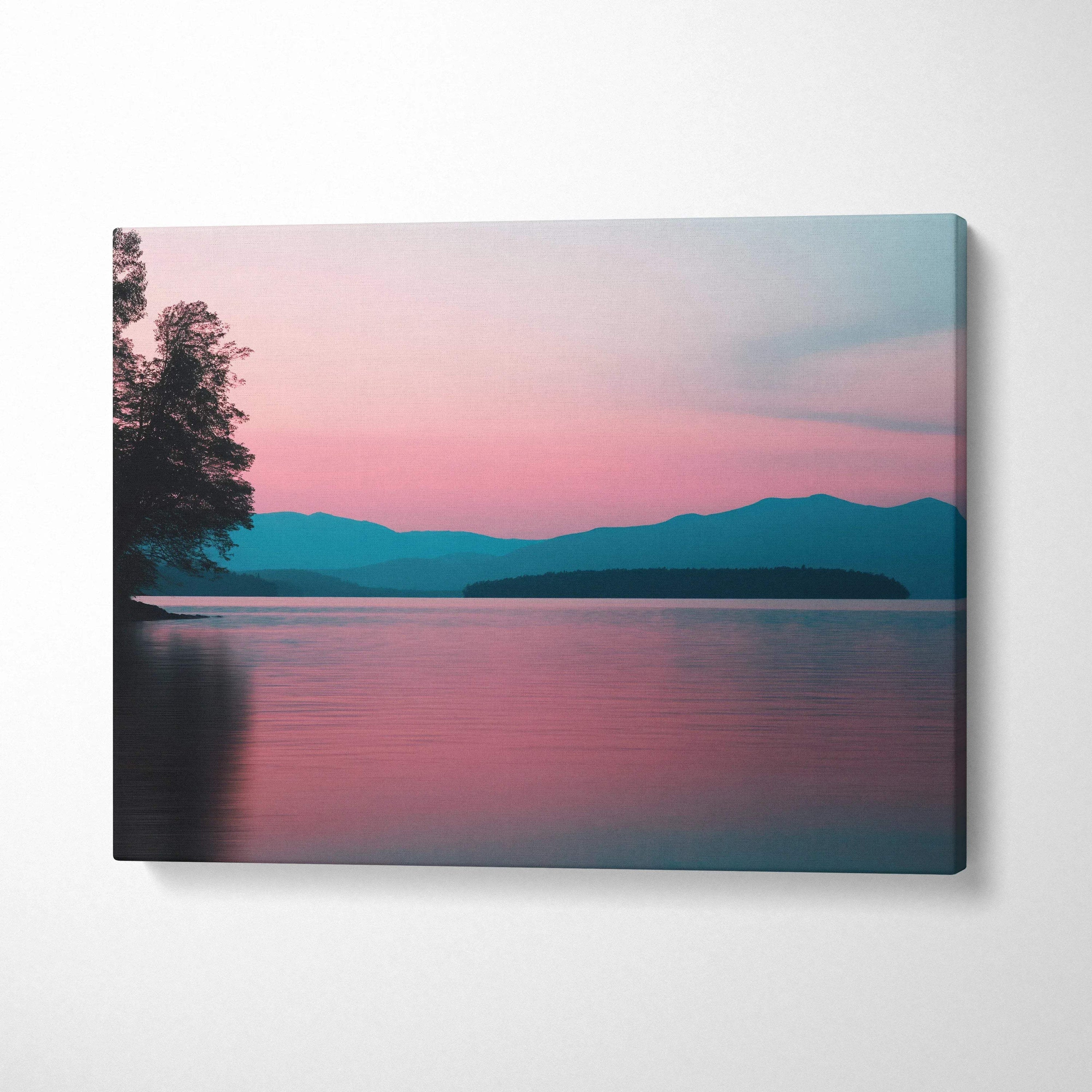 Canvas wall art featuring a tranquil lake at sunset with pink and blue sky hues and silhouetted trees and mountains.