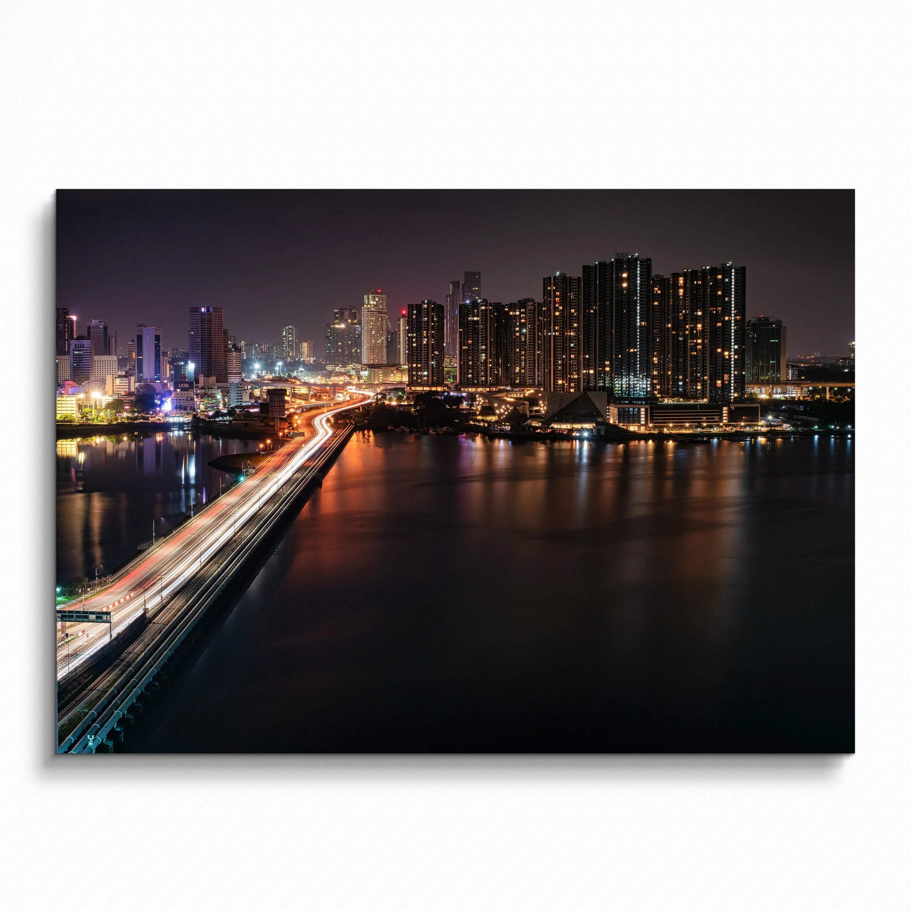 City night skyline wall art poster featuring illuminated buildings and a glowing bridge over water.
