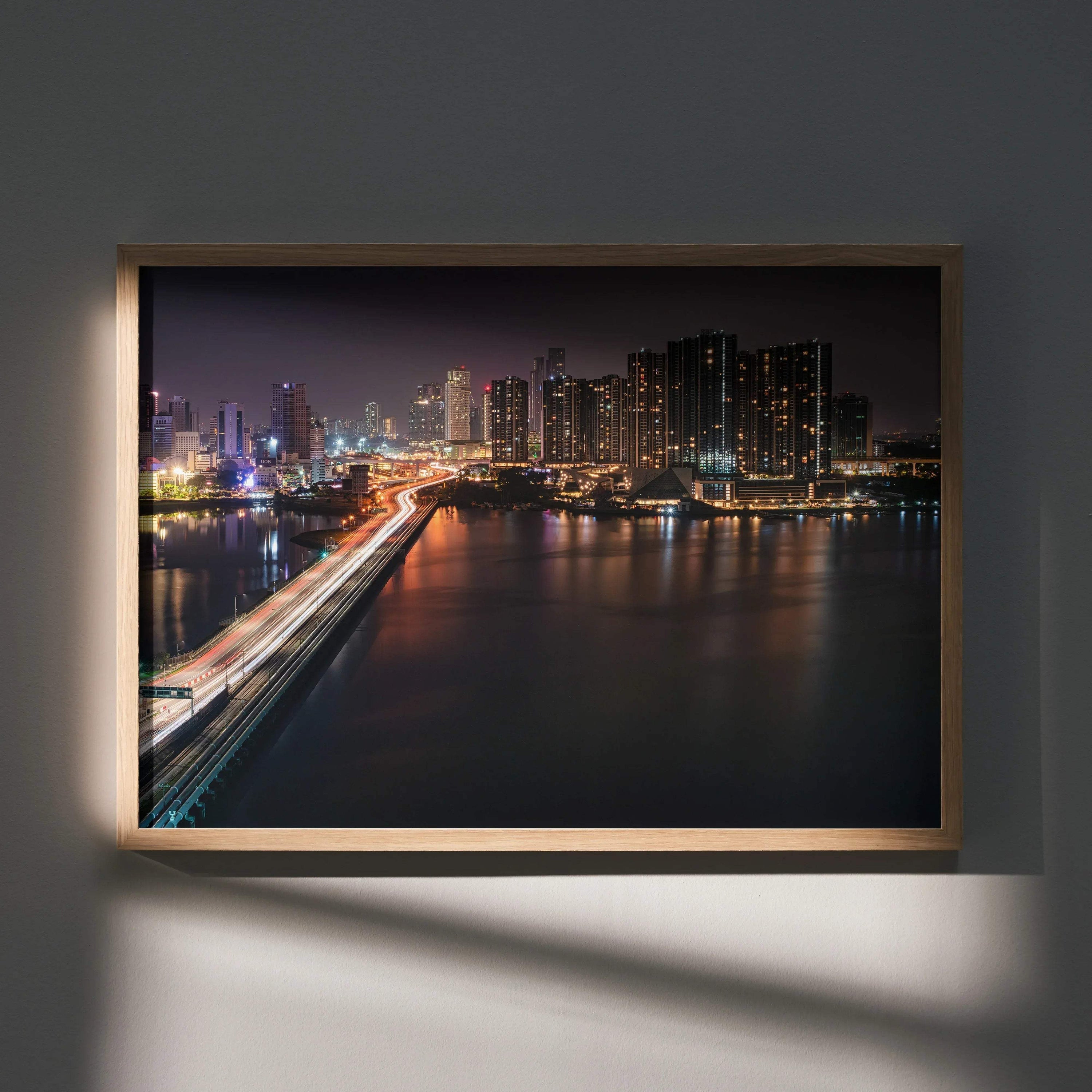 Vibrant city night skyline wall art poster with illuminated buildings and reflections on water, framed wooden wall art.