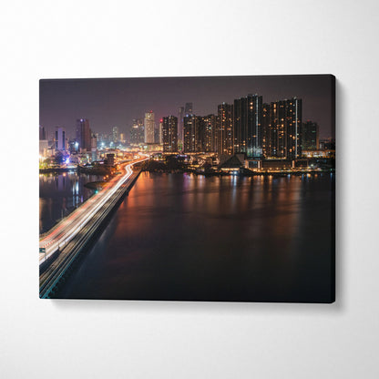 City skyline at night with illuminated buildings and light trails on a bridge on canvas wall art.