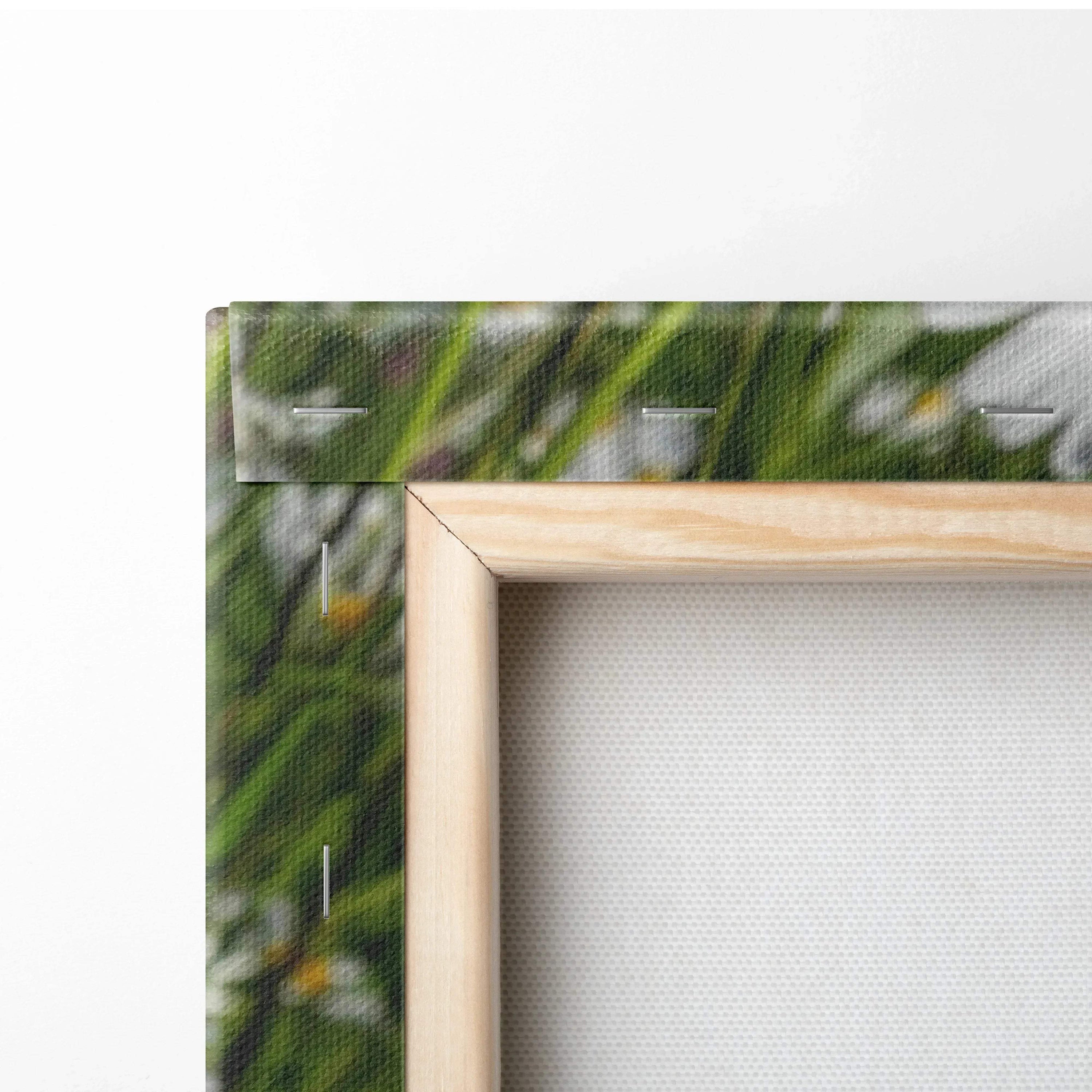 Close-up of wooden frame corner on vibrant floral canvas wall art with green leaves and white flowers.