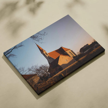 Canvas wall art featuring a serene church building at sunset with warm light and soft shadows.