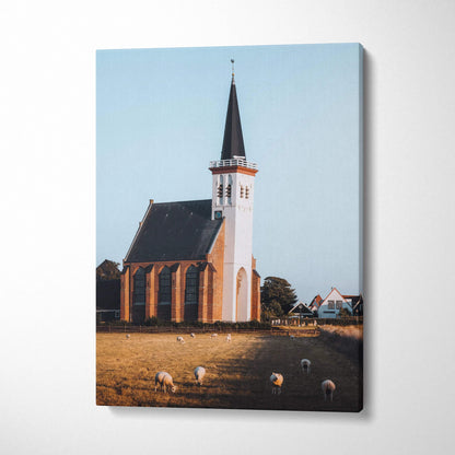 Canvas wall art print of an elegant church with a tall steeple and grazing sheep under a clear sky.